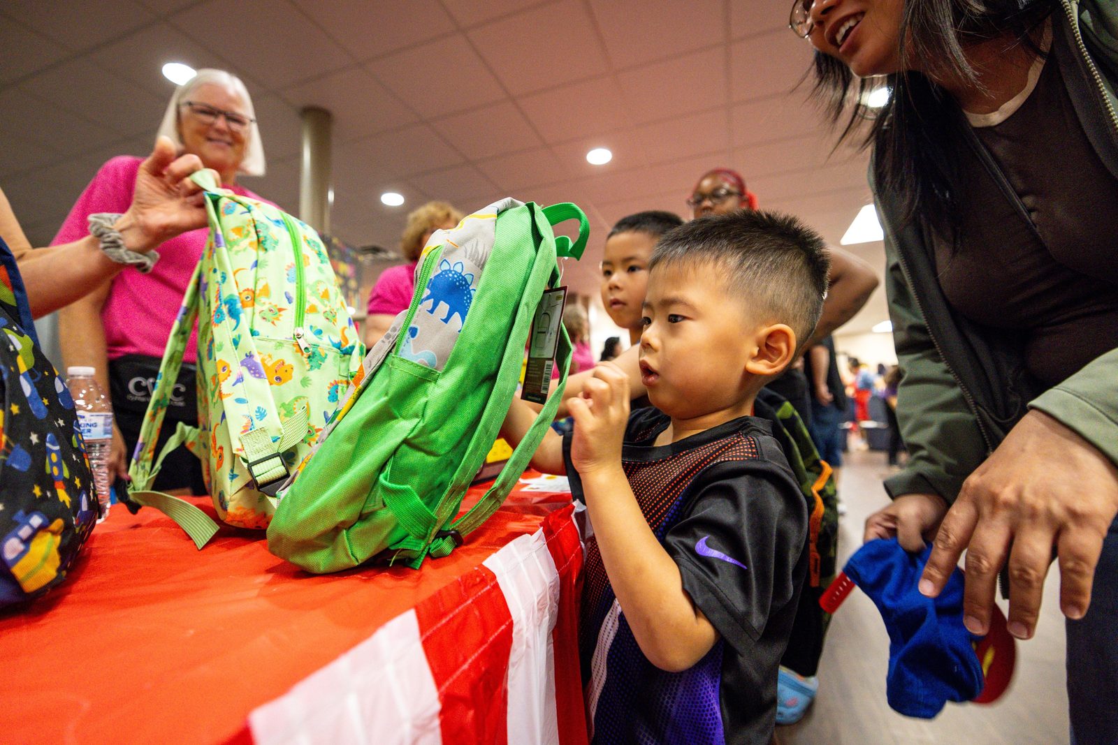 A young boy receives a backpack at a Cy-Fair Helping Hands back-to-school event